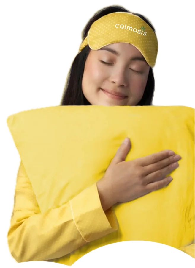 A woman in a sleep mask hugging her pillow